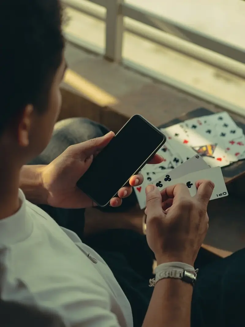 Two hands cupping a dark phone with the screen hidden